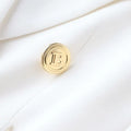 Close-up of luxury quality white office blazer with gold buttons, classic style for women.