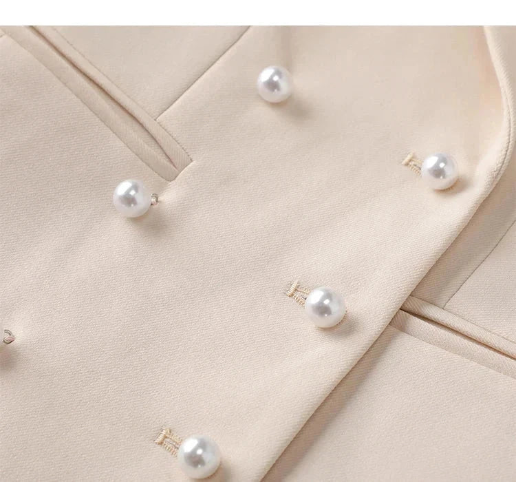 Beige triple-breasted blazer with pearl button detail.