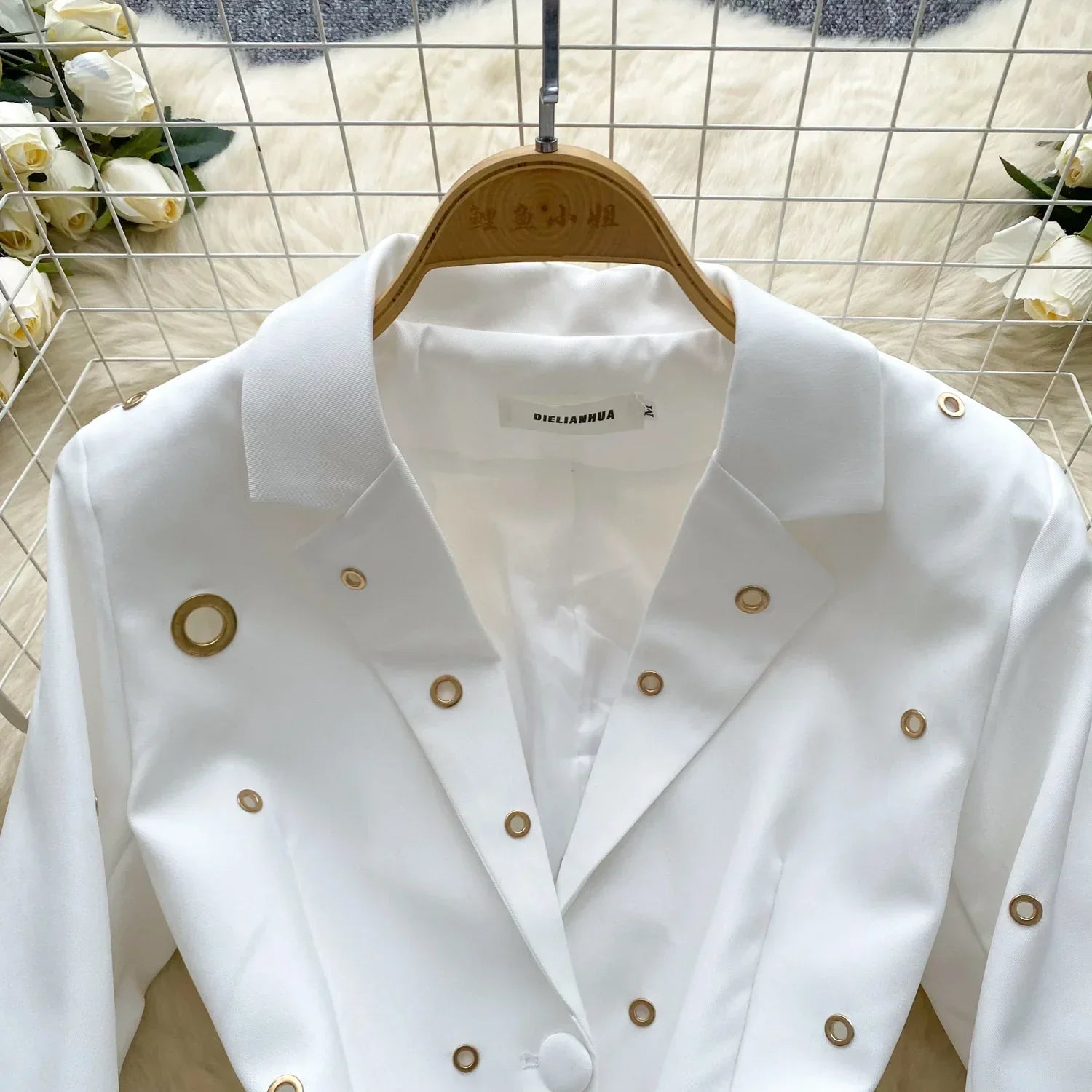 White single-breasted blazer with metal buckle detailing, part of two-piece suit set.