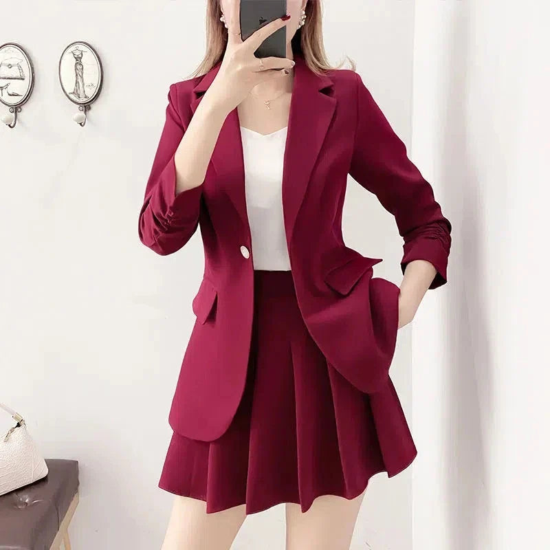 Elegant two-piece women’s blazer and A-line skirt suit in burgundy, featuring a single-button closure and notched collar.