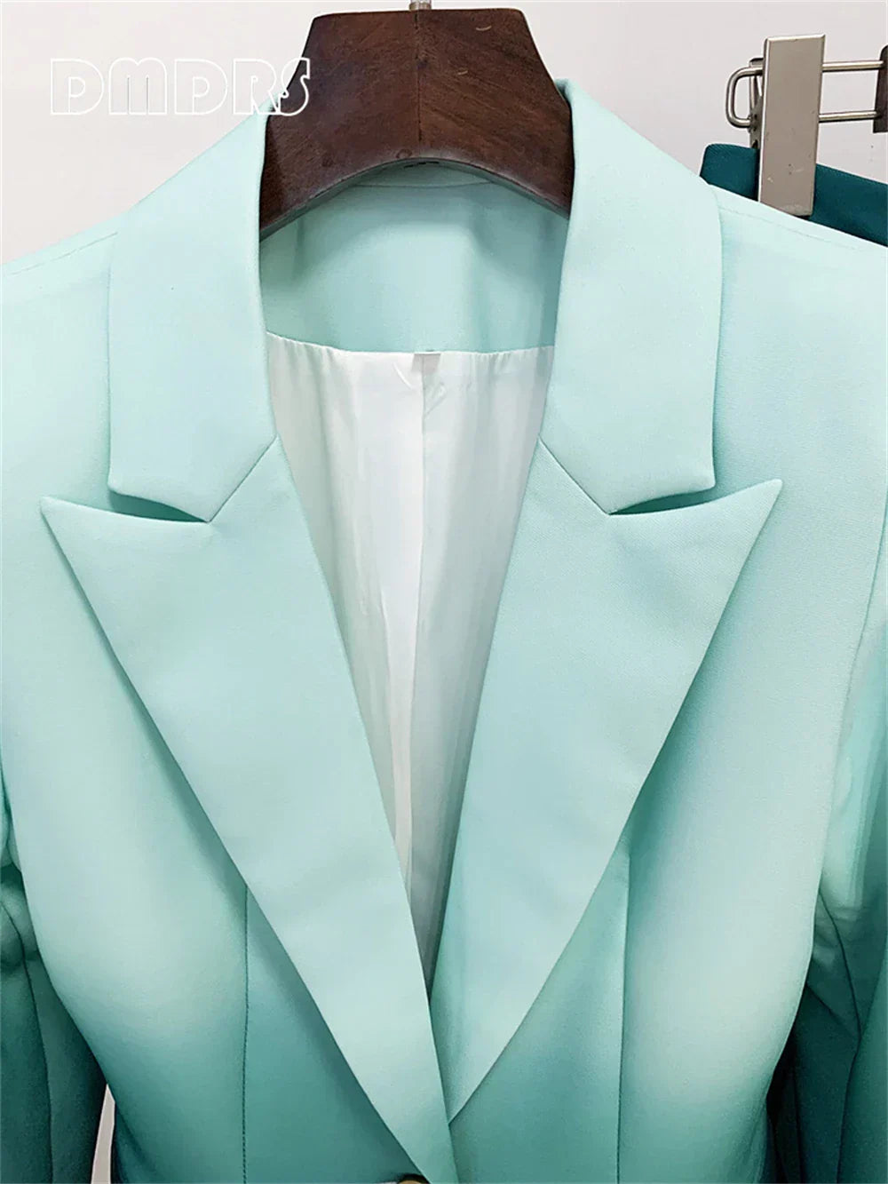 Gradient green women's slim-fitting suit set with notched collar blazer on hanger.