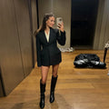 Woman wearing elegant black blazer with slim lapel and long sleeves in a stylish outfit.