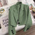 Women's loose solid color short suit jacket with a notched collar and single-button closure.