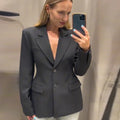 Elegant women's black blazer with slim lapel and single button, ideal for office wear.