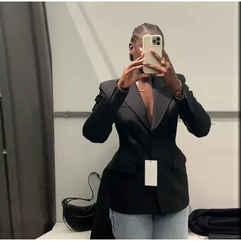 Elegant women's black suit jacket with slim lapel and single button, worn by a person taking a selfie in a changing room.