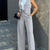 Women's casual slim notched blazer and high waist pant set in light grey, featuring a sleeveless cardigan style.