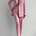 Two piece women's blazer suit in pink, double-breasted, long sleeve, with pencil pants.