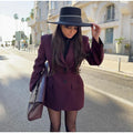 Woman wearing an elegant black blazer with a slim lapel and single button closure.