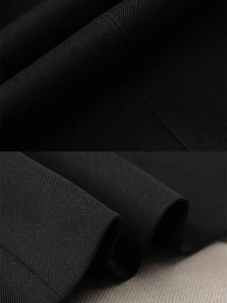 Close-up view of the fabric and stitching on a black women's triple-breasted blazer.