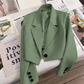 Women's loose solid color short suit jacket in green with black buttons.