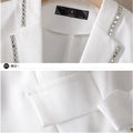 White women's blazer with sequin decoration, notched collar, and single button closure.