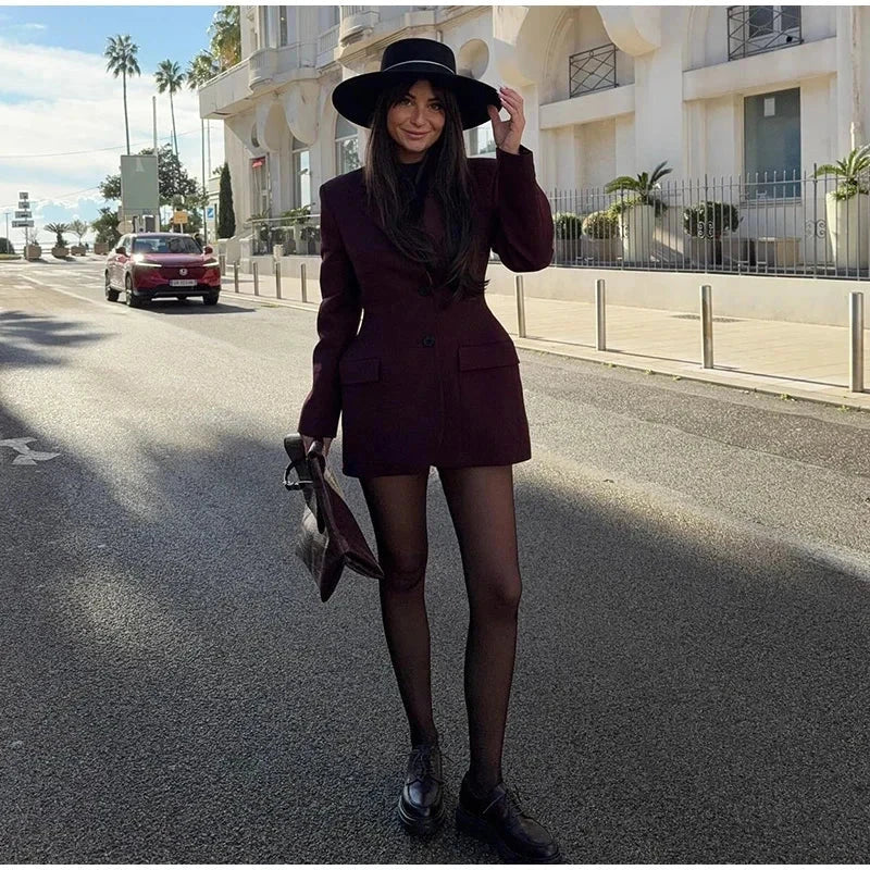 Woman wearing an elegant black blazer with slim lapel and long sleeves.