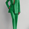 Women's green two-piece suit with long sleeve double-breasted blazer and pencil pants.