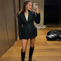 Elegant women's black blazer with slim lapel, single button, and long sleeves.