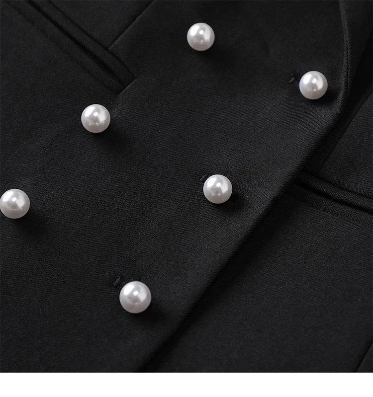 Close-up of a black triple-breasted blazer with pearl-like buttons.